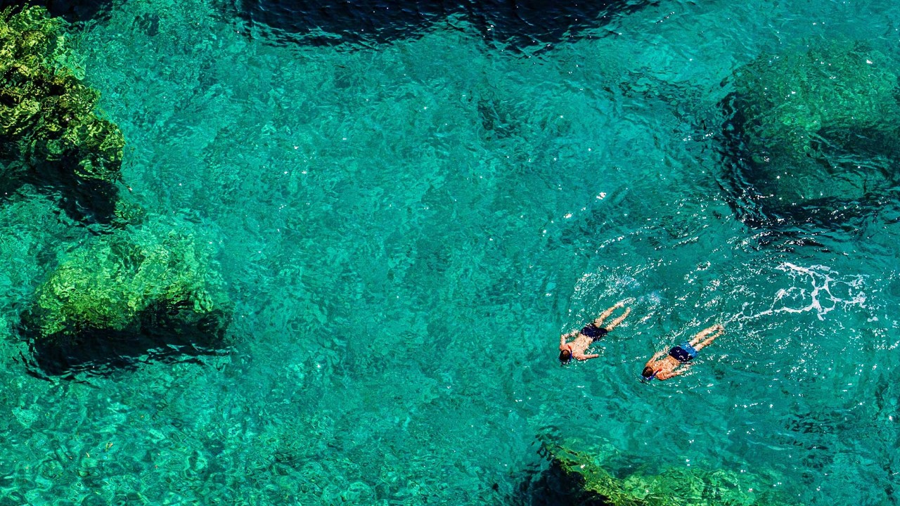 两人在湛蓝的水里游泳
